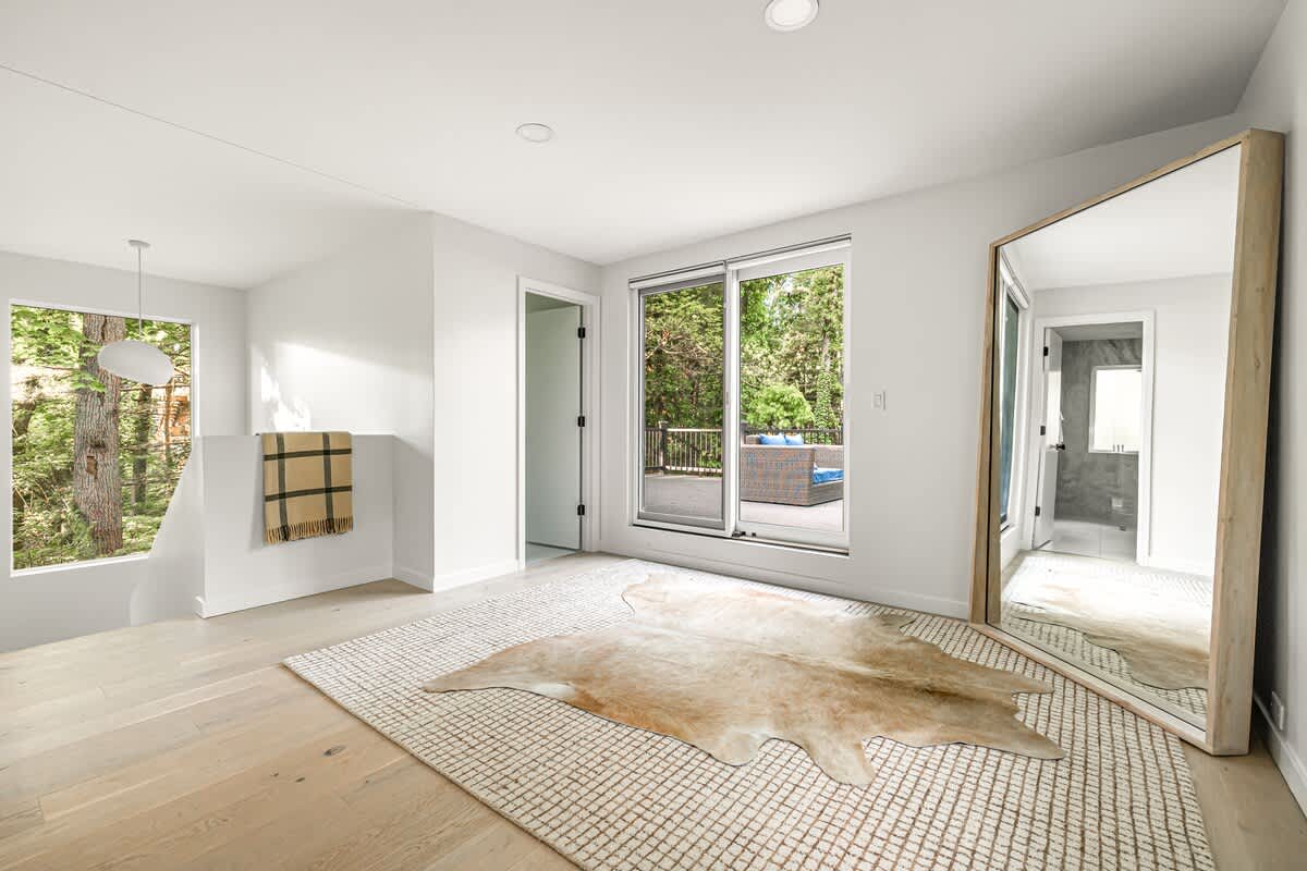 This room’s got main character energy: natural light, a statement mirror, and a balcony to top it off.
