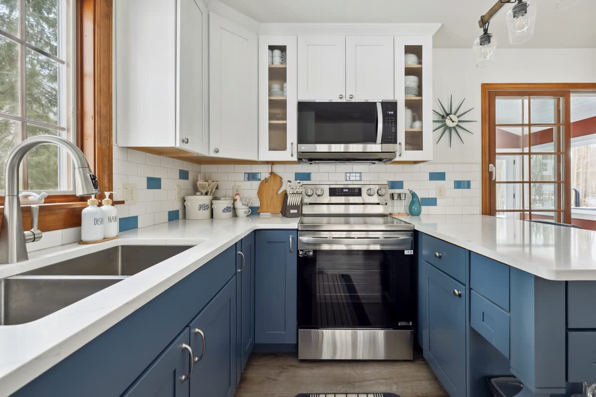 Blue cabinets, sleek appliances, and just enough counter space to pretend I’m on a cooking show.