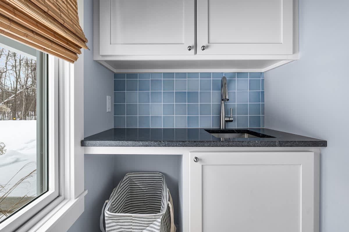 Charming and functional! A stylish laundry sink with a fresh coastal vibe.