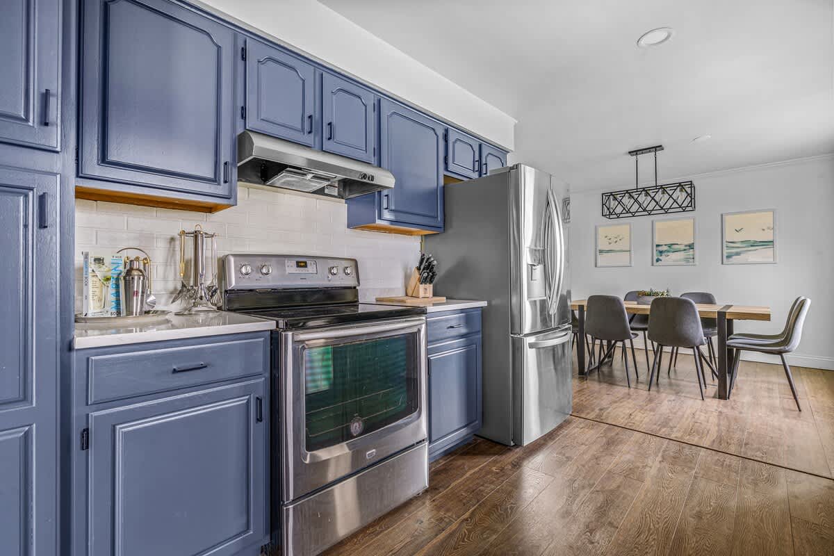 The blue cabinets bring a pop of color while the stainless-steel appliances add that modern touch!