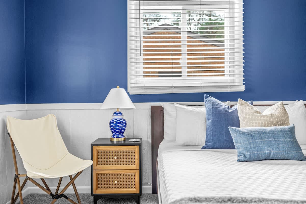 Pop of blue, tailored vibes, and natural light. This bedroom is all about comfort and charm.