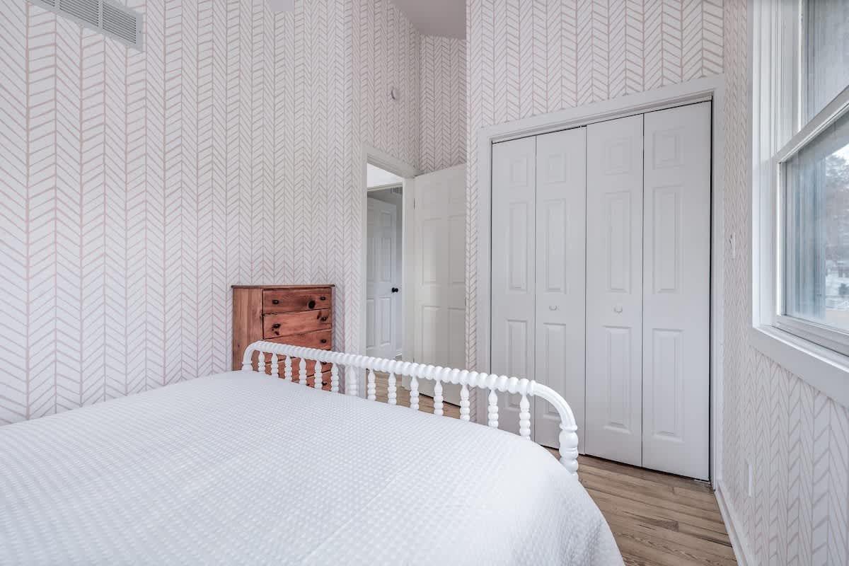 This ambient-chic bedroom with playful wallpaper and sunshine pouring in is the perfect retreat after a day of adventure or chill.