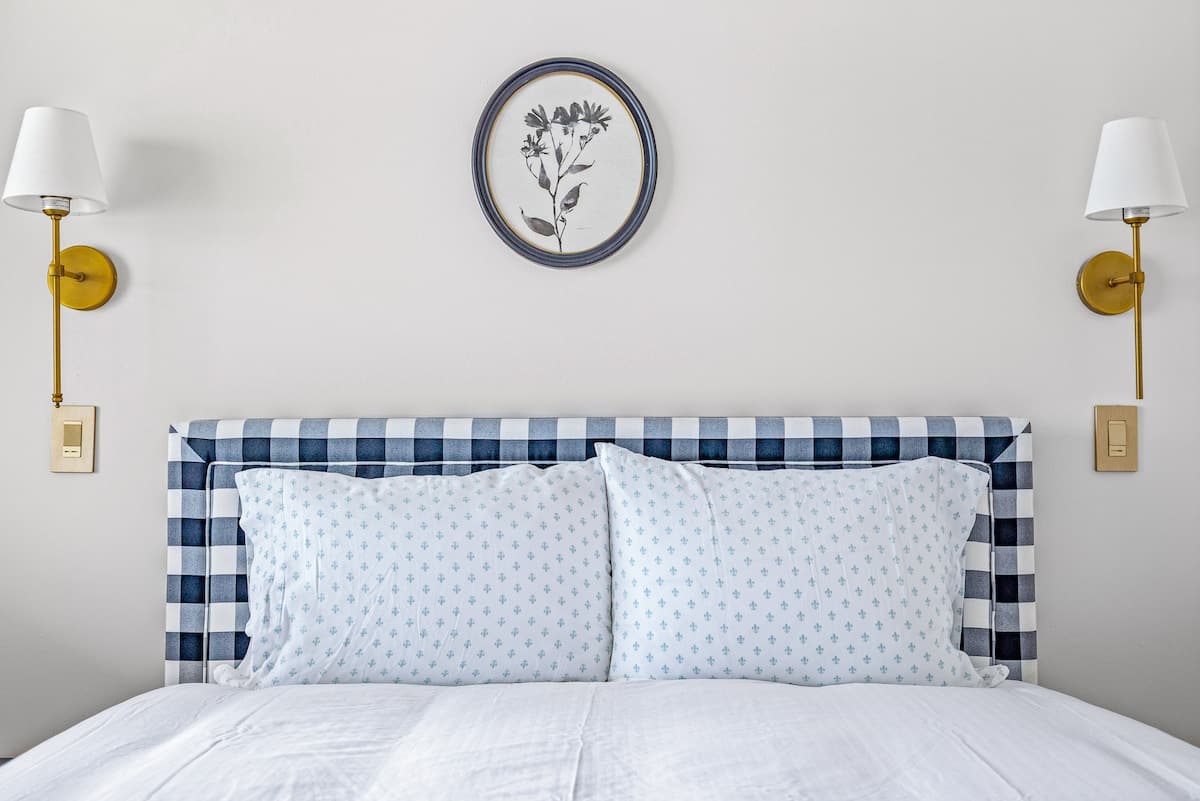 Fluffy pillows, soft light, and a checkered headboard that’s oh-so-cute!