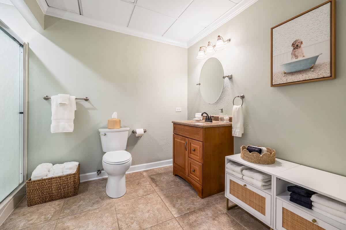 Fresh towels, soft lighting, and even a pup in the tub—every detail says welcome.