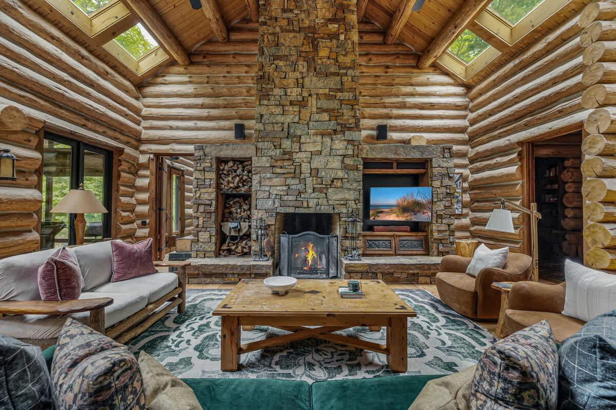 A warm, lodge-style living room with a stunning stone hearth and rustic charm.