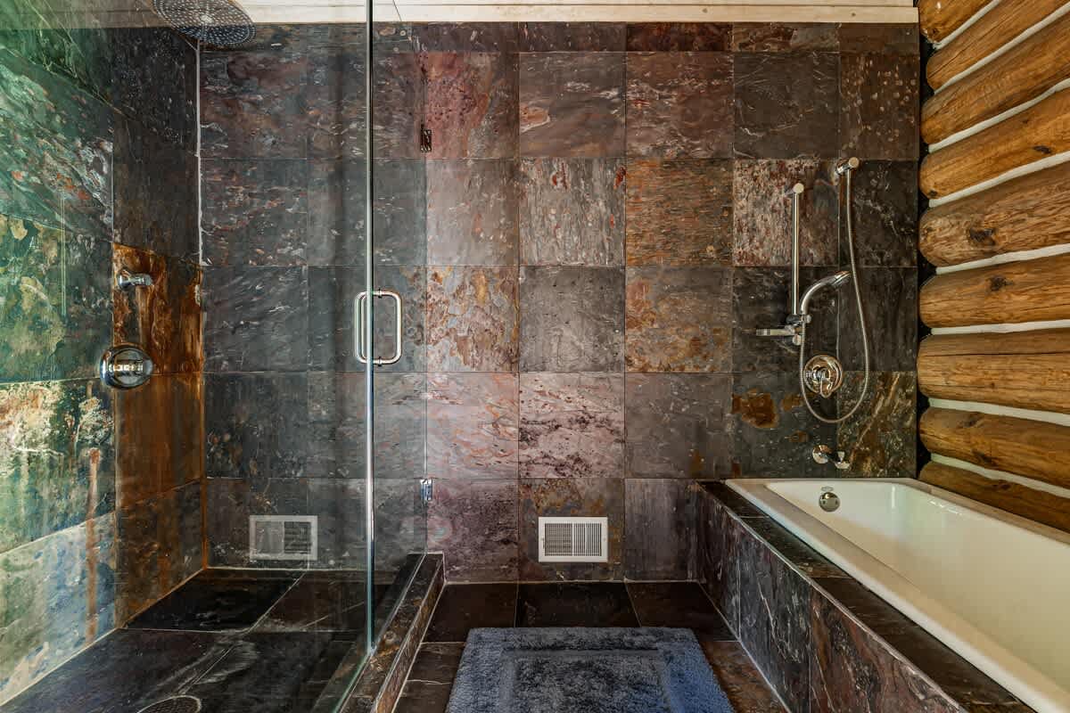 Slate-tiled shower + soaking tub = cabin spa vibes