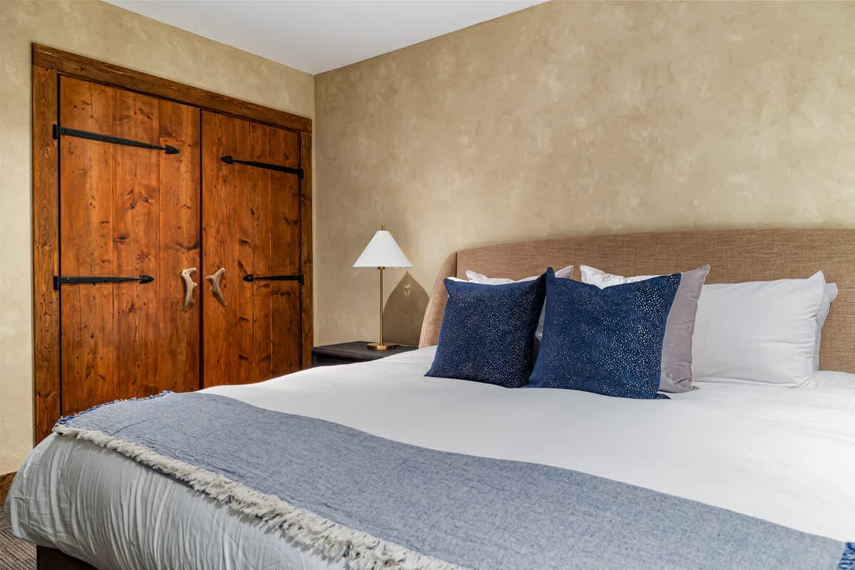 Escape to luxury in a lavish bedroom with a plush bed and classic wood closet.