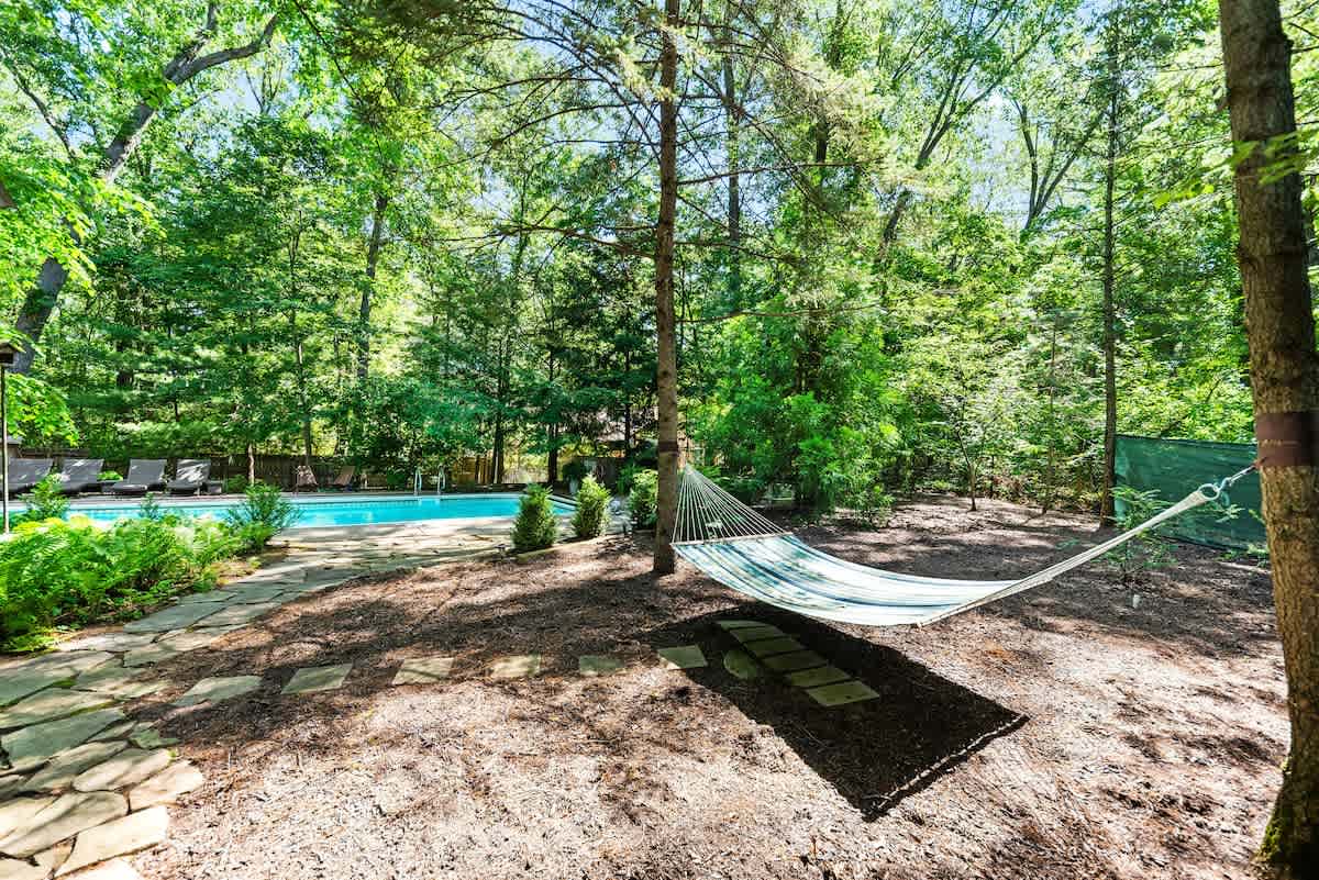 Sway beneath the trees, steps from the pool.
