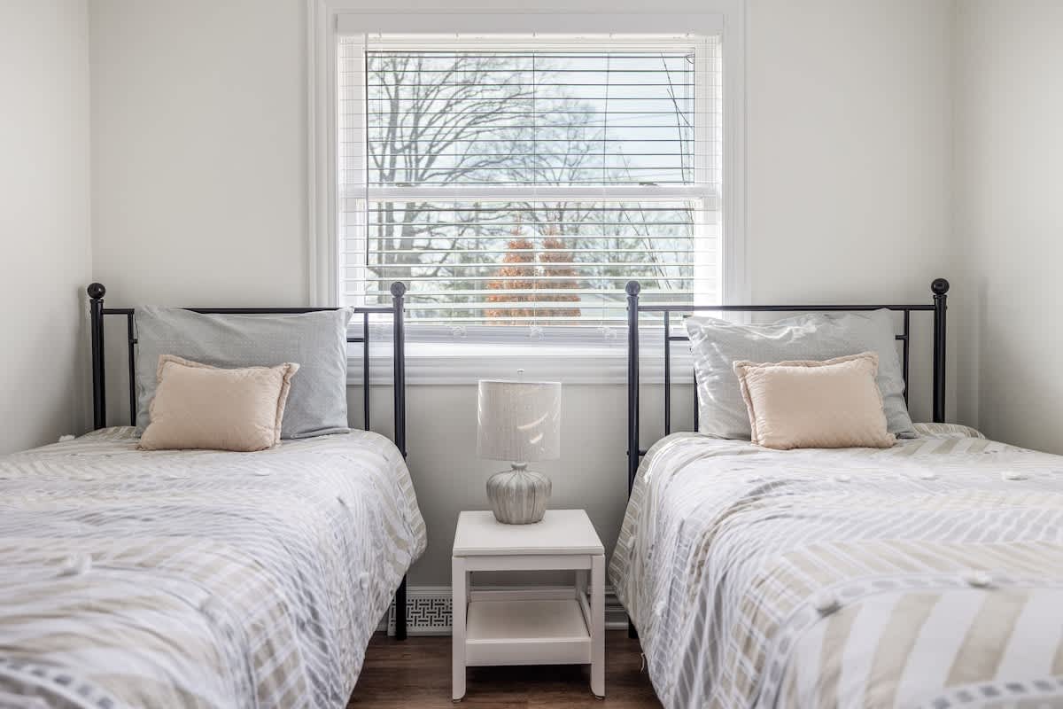 Cozy twin setup with soft light—great for guests who love space and togetherness.