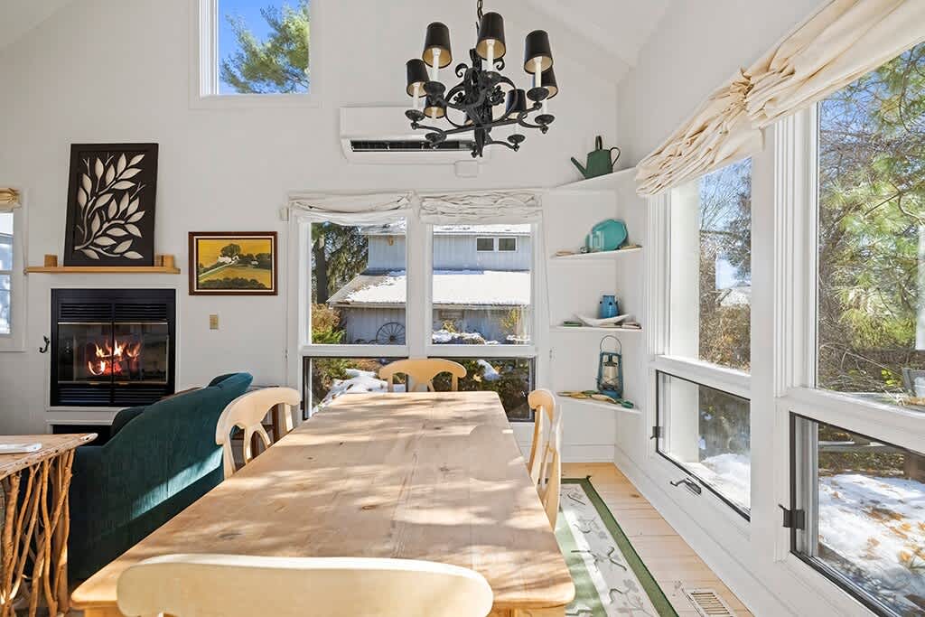 A cheerful Cottage dining space wrapped in windows and natural light.