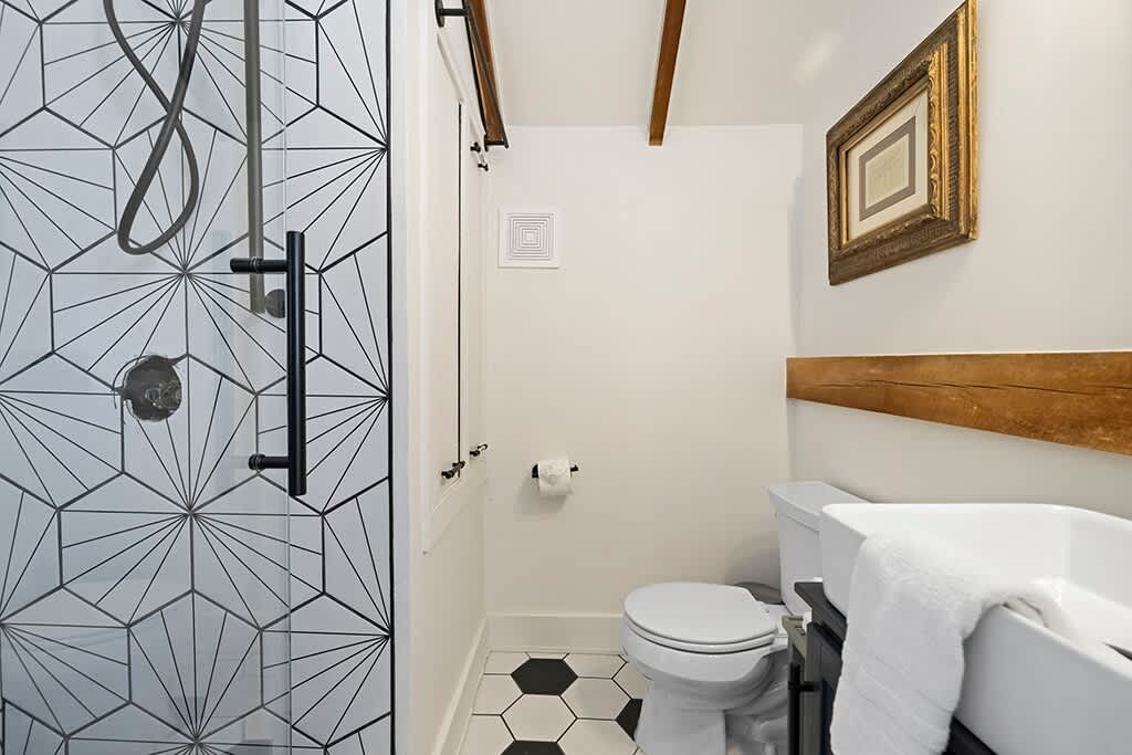 The Loft’s modern bath with bold tile and warm farmhouse touches.