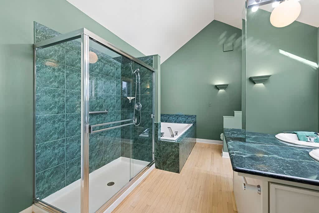 The Farmhouse’s primary bath pairs roomy comfort with calming green tones.