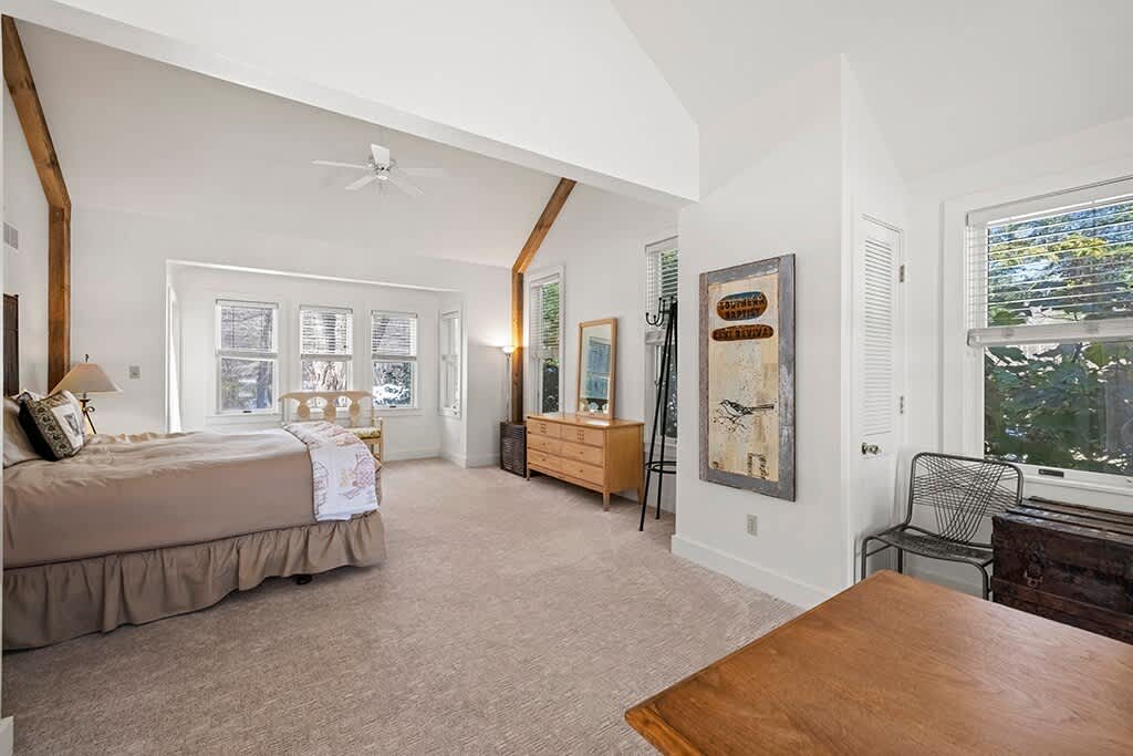 The airy primary bedroom creates a peaceful haven at the heart of The Farmhouse.