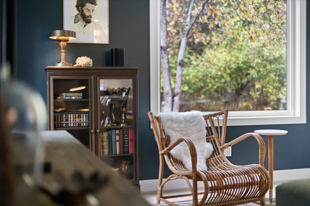 A quiet reading nook framed by woodland views and warm light.