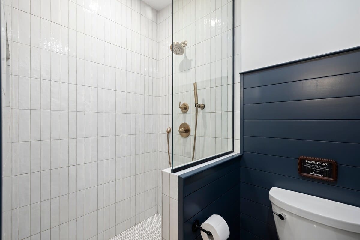 Crisp tile and brass fixtures create a spa-like shower retreat.