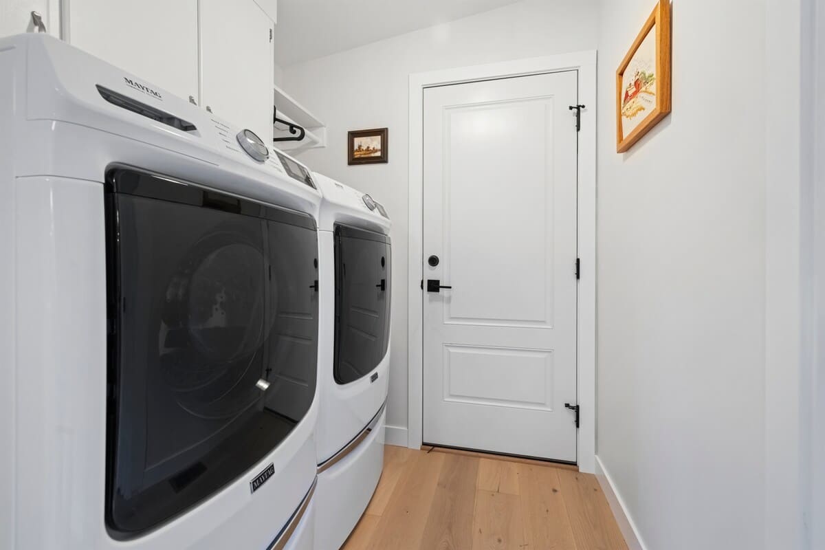 Full laundry room with washer, dryer, and storage space.
