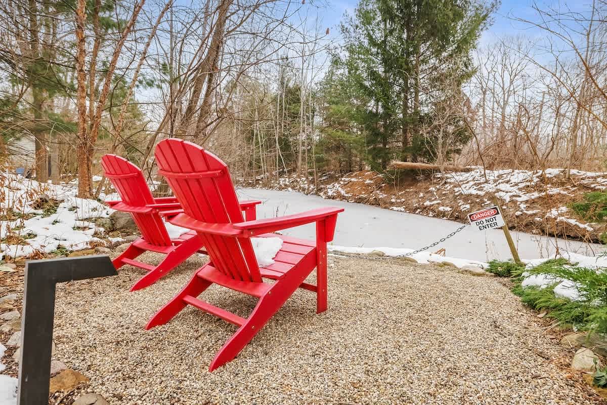 Bright red chairs for quiet moments in Star Cottage’s wooded yard.