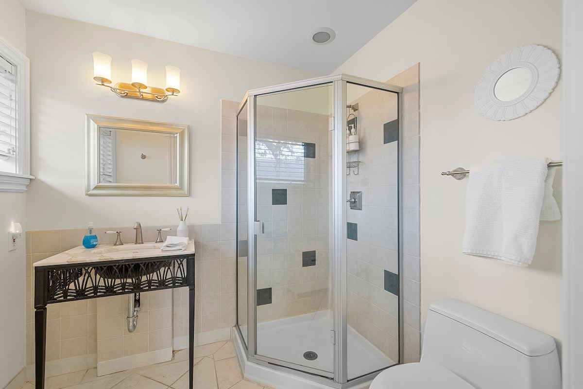 Spacious bathroom with walk-in shower, elegant fixtures, and natural light.