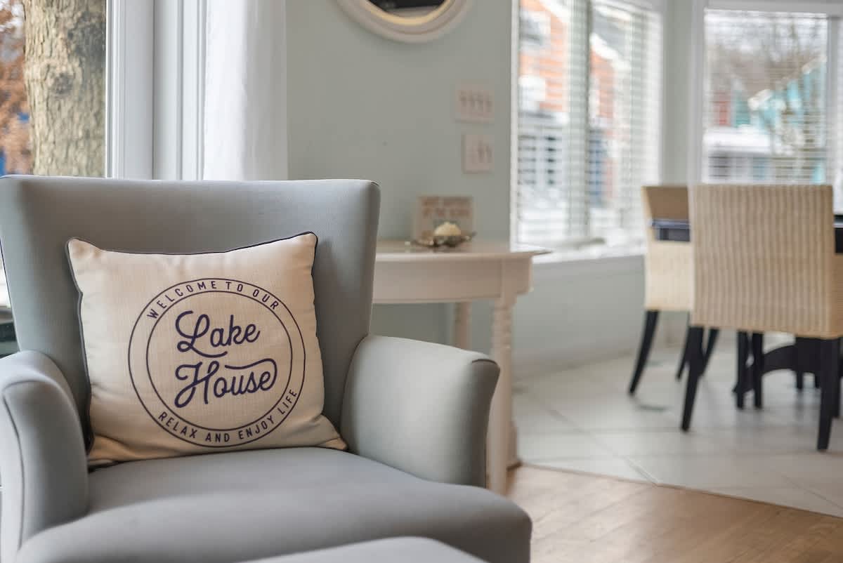 Sink into this cozy armchair with lake house charm and sunlit windows.