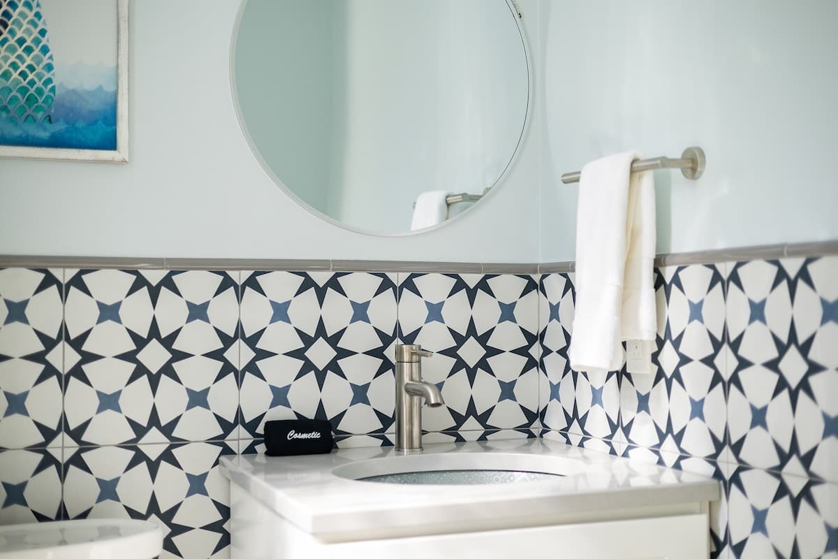 A stylish half bath with geometric tile and modern touches.