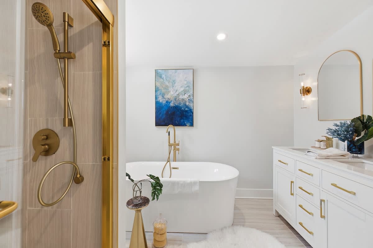 Indulge in a spa experience with a deep soaking tub and gold finishes.