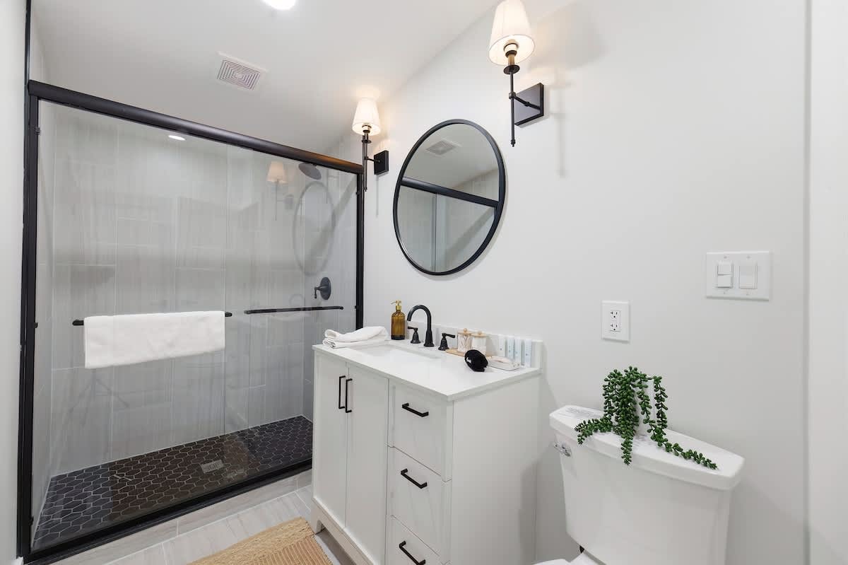Modern black accents and a bright vanity create a crisp, clean retreat.