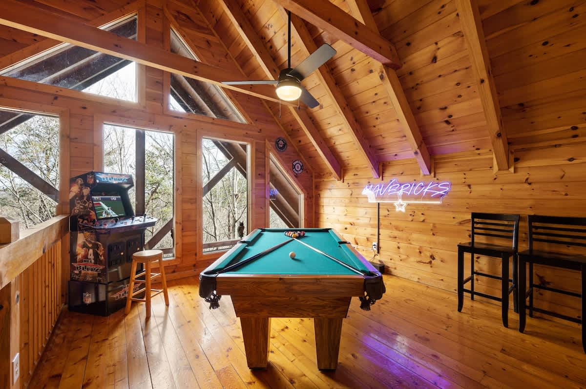 A neon sign lights the game room area, including NFL Blitz!