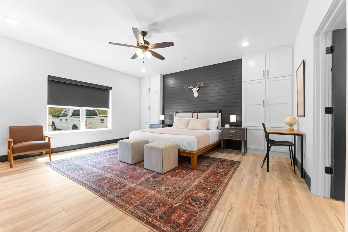 Primary Bedroom, with a desk, lounge chairs, and attached bathroom.  Note that this room can be accessed without stairs and also has larger doors for handicap accessibility.  Also note the WHITE NOISE MACHINE (in every bedroom)