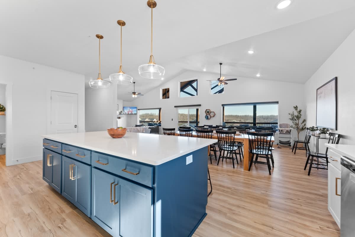 Kitchen looking onto the dining room with vaulted ceilings and large windows to take in the view