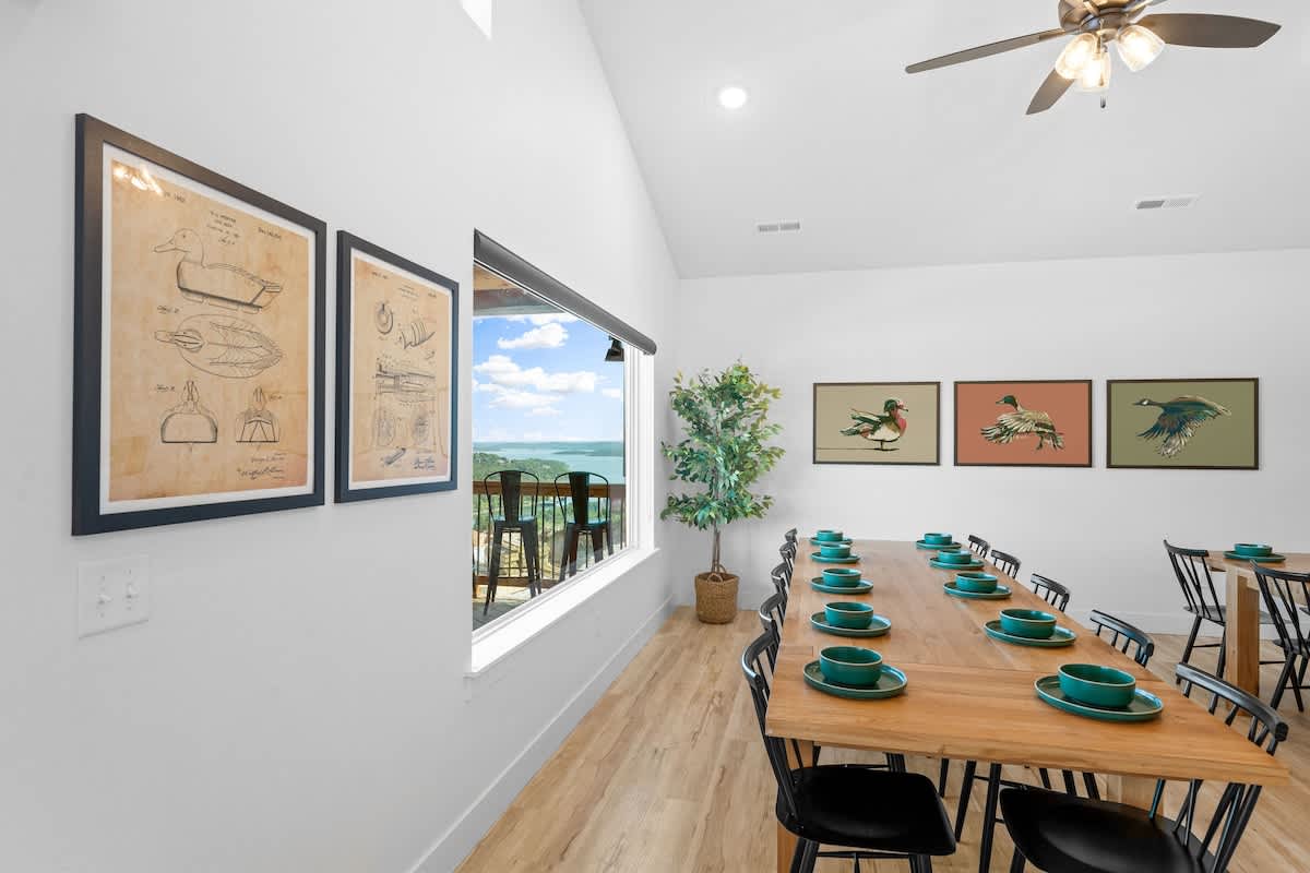 2 large dining tables with a view of the lake from the back deck of the cabin