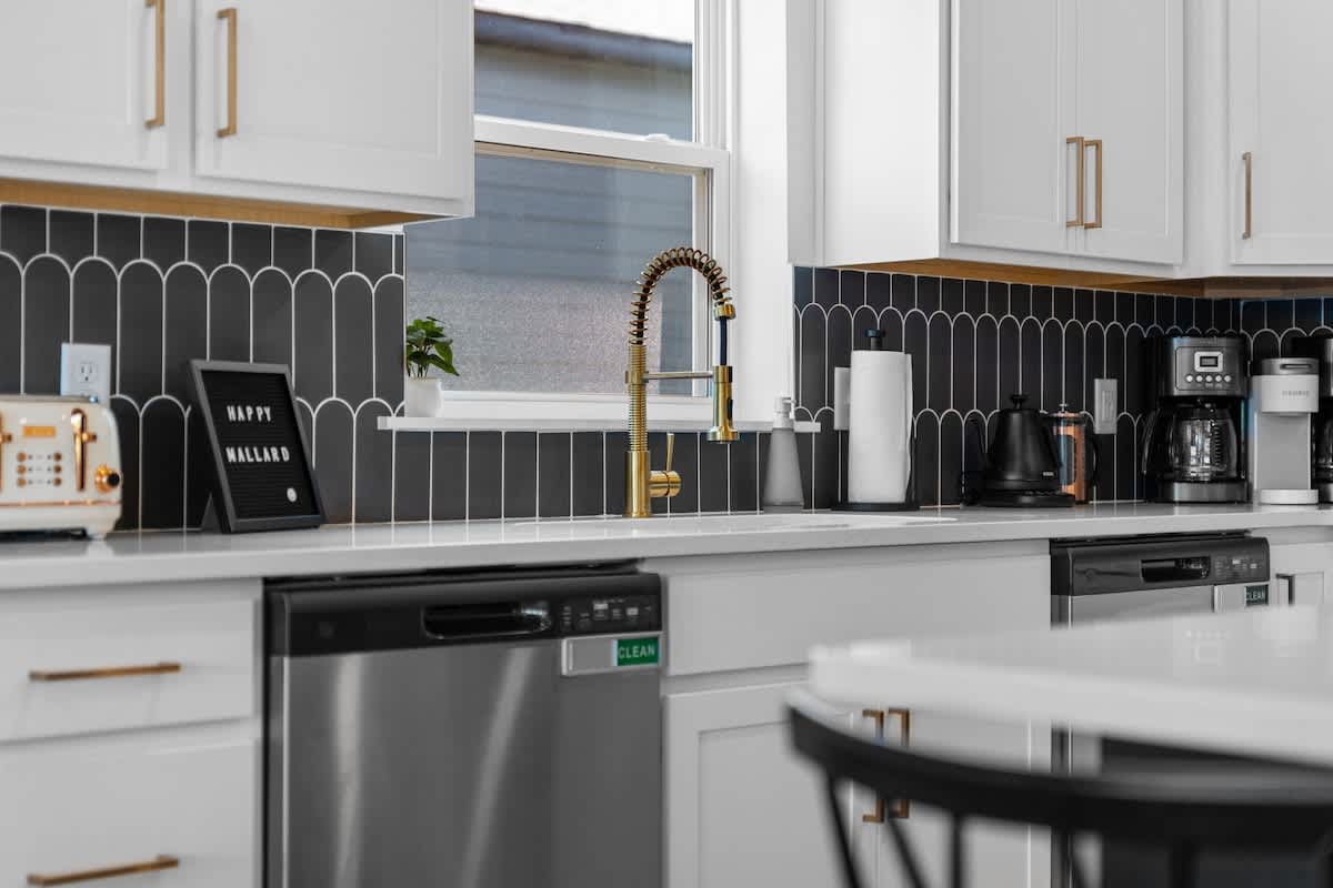 Kitchen has gold hardware with all of the appliances you could ever want