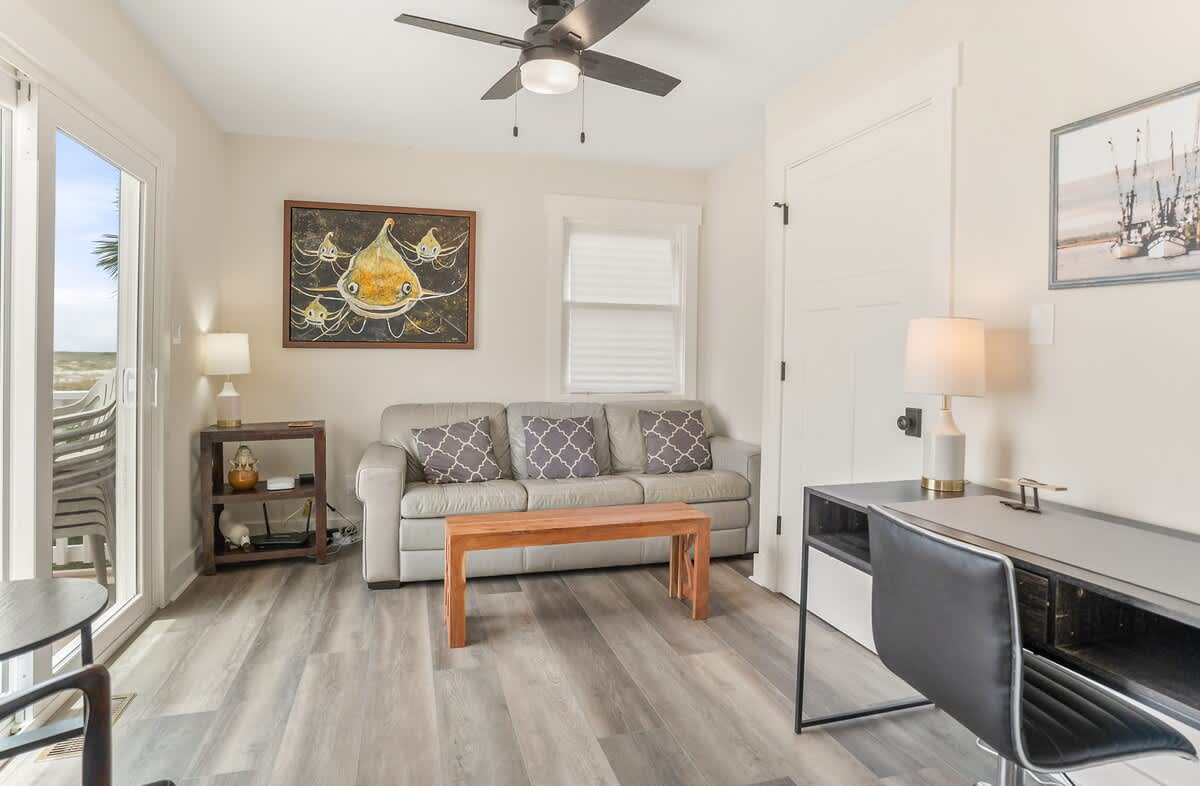 A Cozy Study with a Sofa and Desk Along with Washer and Dryer 