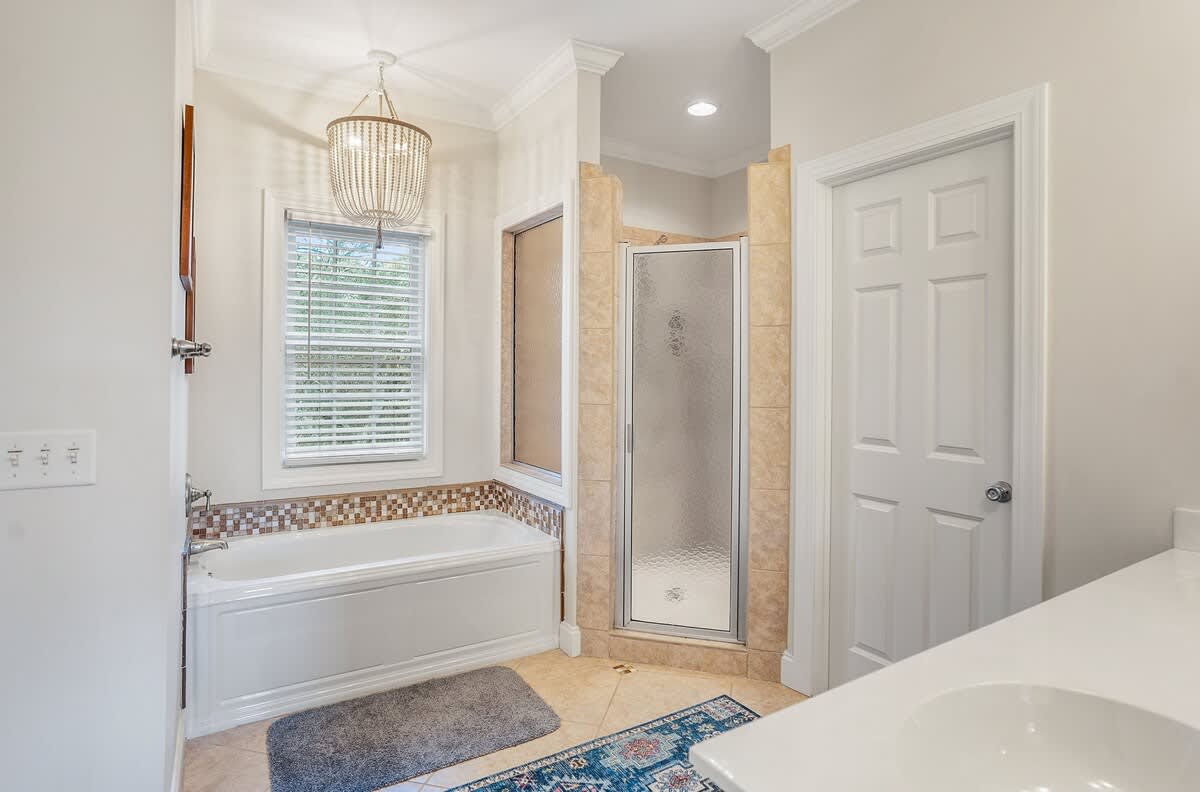 Large Primary Ensuite Bathroom with a Drop-In Tub, Walk-In Shower with Dual Shower Heads, Double Vanity, and Private Water Closet.