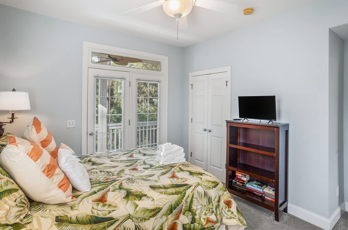 First Floor Queen Bedroom with a Streaming TV, Private Balcony, and Attached Bathroom with a Shower-Tub Combo with Convenient Hallway Access.