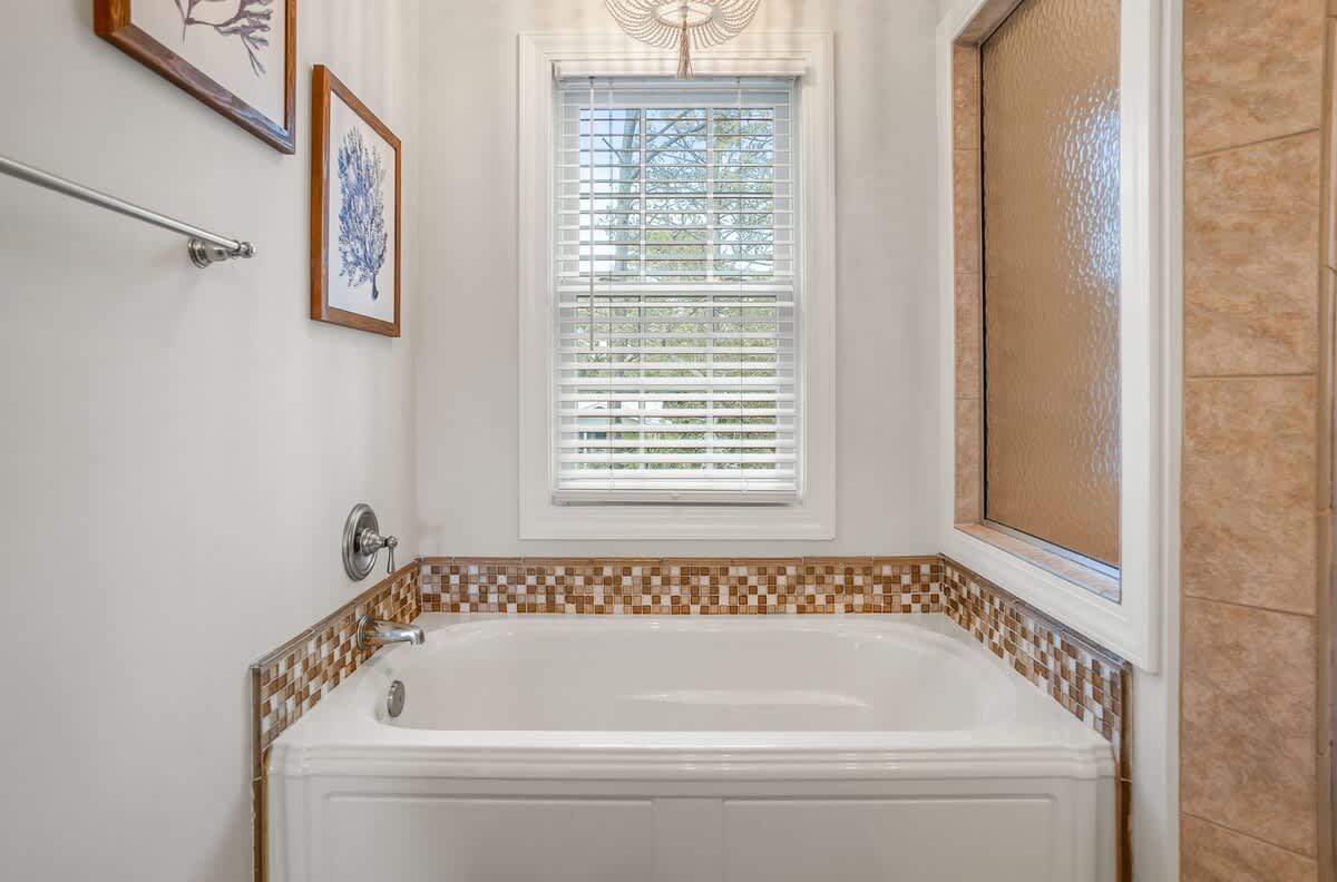 Large Primary Ensuite Bathroom with a Drop-In Tub, Walk-In Shower with Dual Shower Heads, Double Vanity, and Private Water Closet.