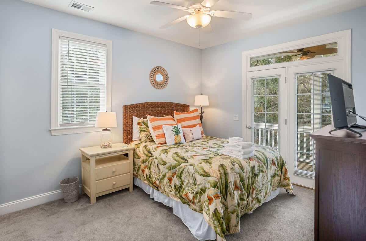 First Floor Queen Bedroom with a Streaming TV, Private Balcony, and Attached Bathroom with a Shower-Tub Combo with Convenient Hallway Access.