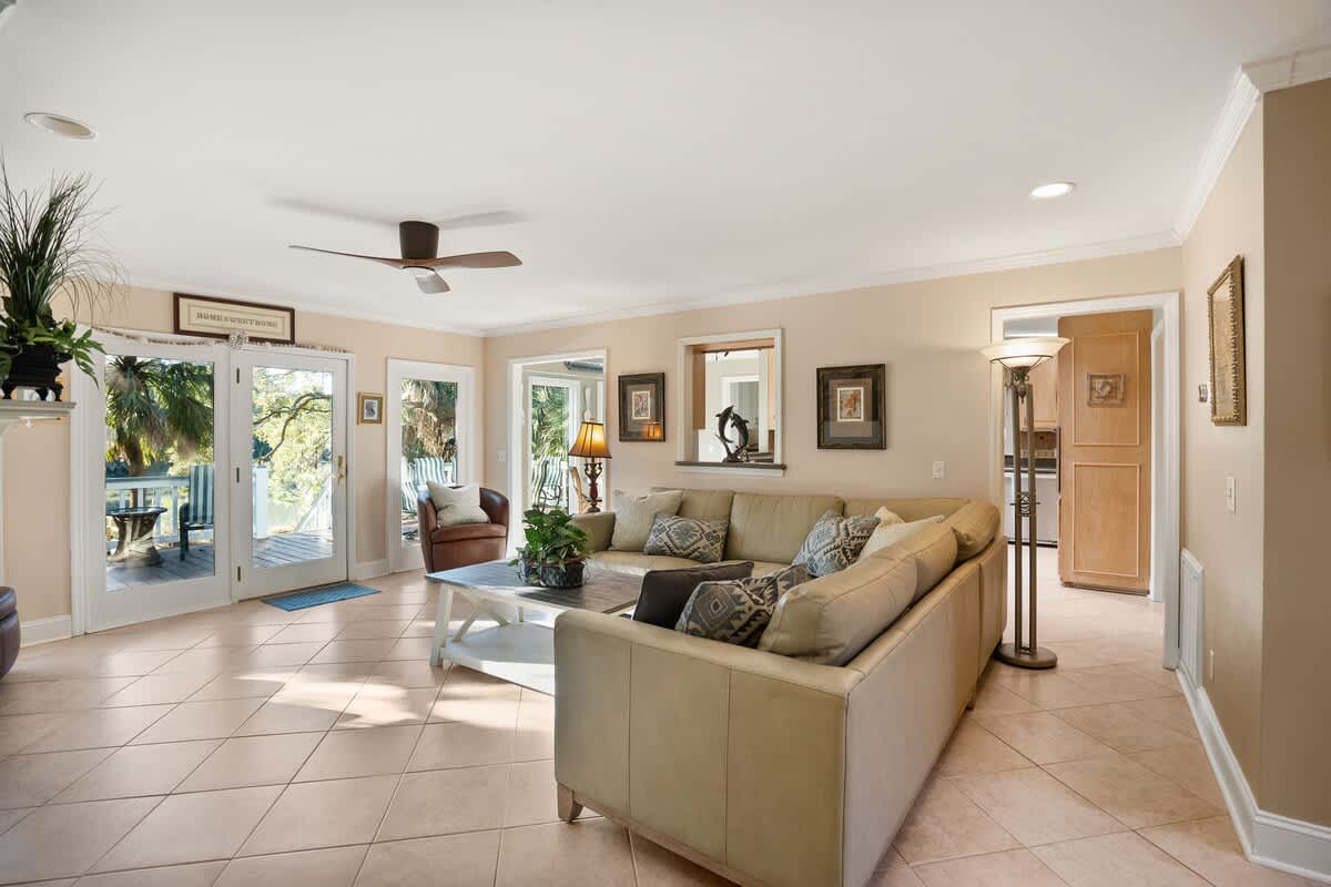 Living Area Includes a Leather Couch, Chairs, Coffee Tables, and End Tables, Along with a Smart TV.