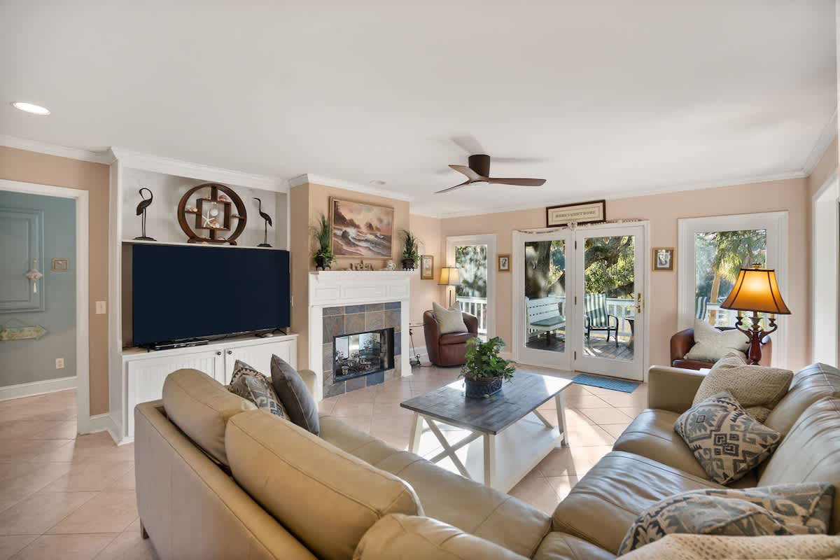 Living Area Includes a Leather Couch, Chairs, Coffee Tables, and End Tables, Along with a Smart TV.