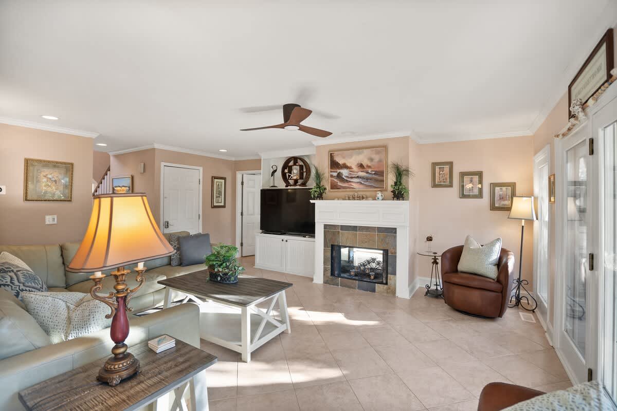 Living Area Includes a Leather Couch, Chairs, Coffee Tables, and End Tables, Along with a Smart TV.