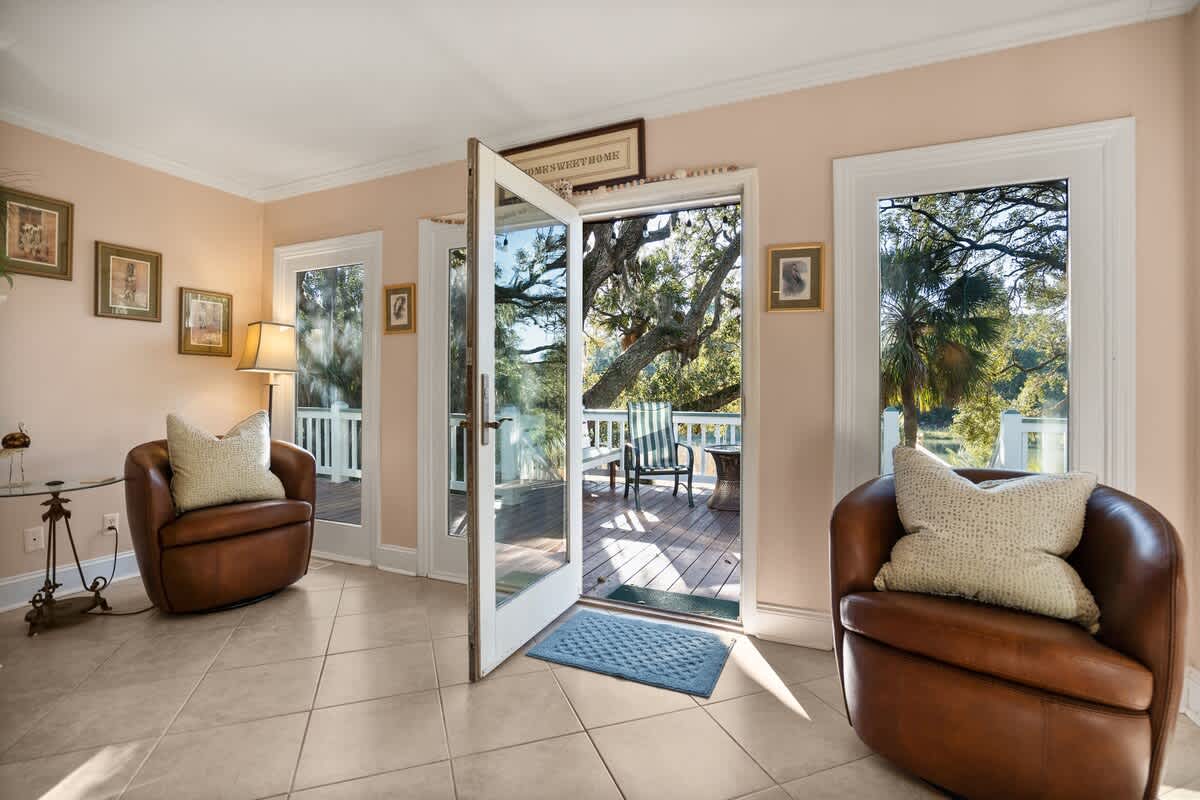 Living Area Includes a Leather Couch, Chairs, Coffee Tables, and End Tables, Along with a Smart TV.