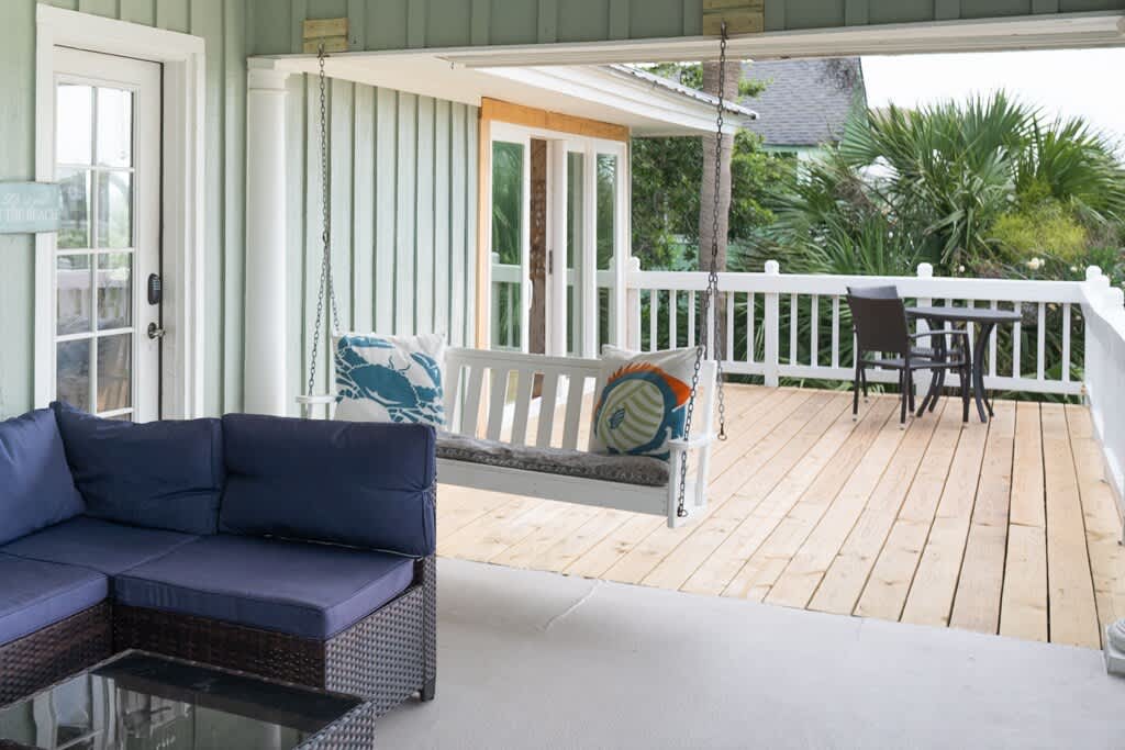 Front Door and Front Porch Area with Porch Swing and Table and Chairs off Sliding Glass Door to Living Room