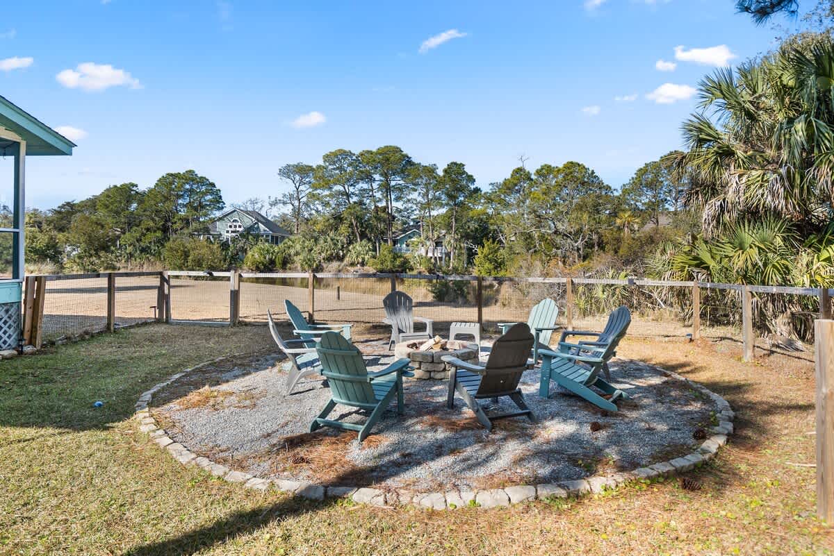 Beautiful backyard outdoor living space with water views, fenced yard and fire pit.
