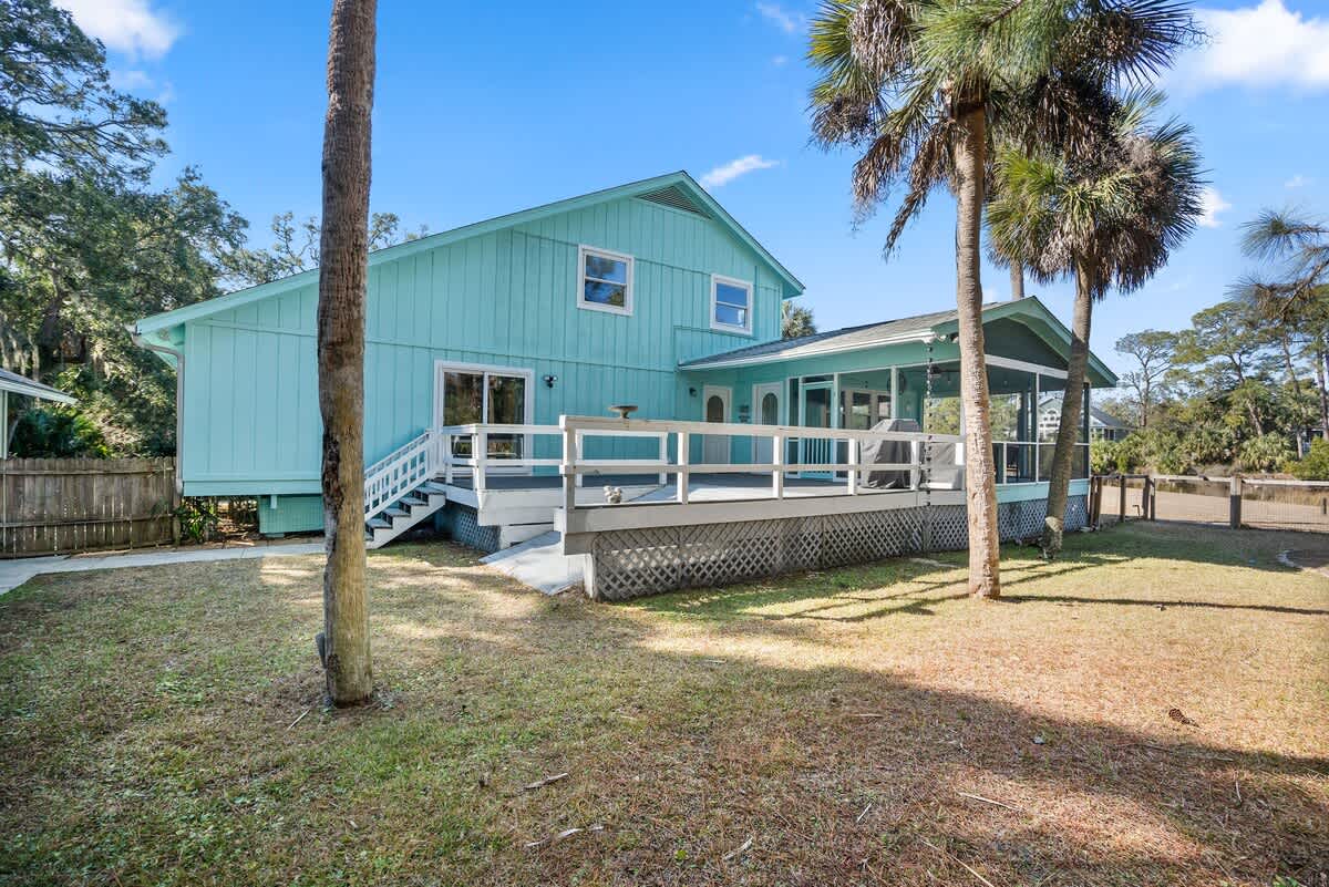 Beautiful backyard outdoor living space with water views, fenced yard and fire pit.