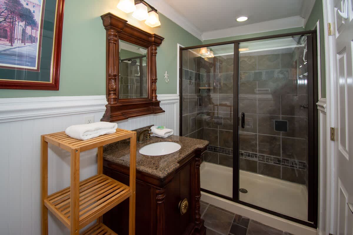Second floor bedroom area with queen bed, trundle day bed, and en suite full bathroom.