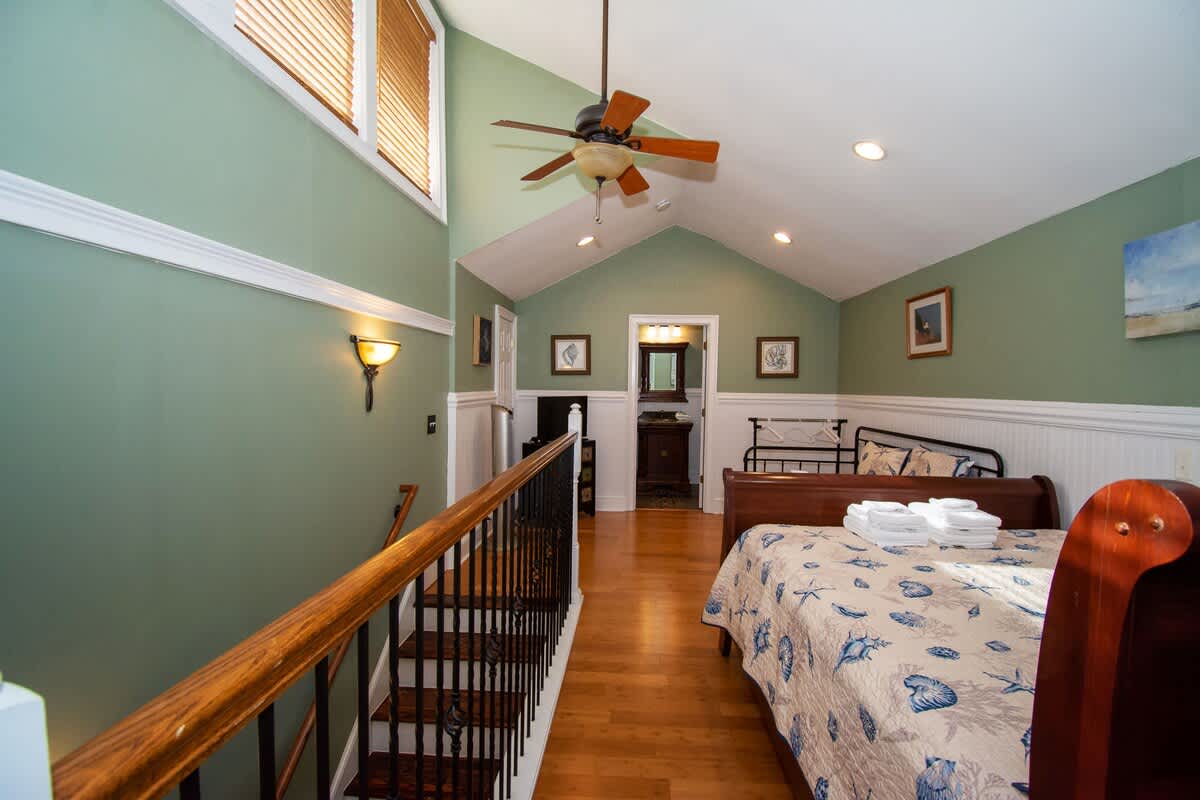 Second floor bedroom area with queen bed, trundle day bed, and en suite full bathroom.