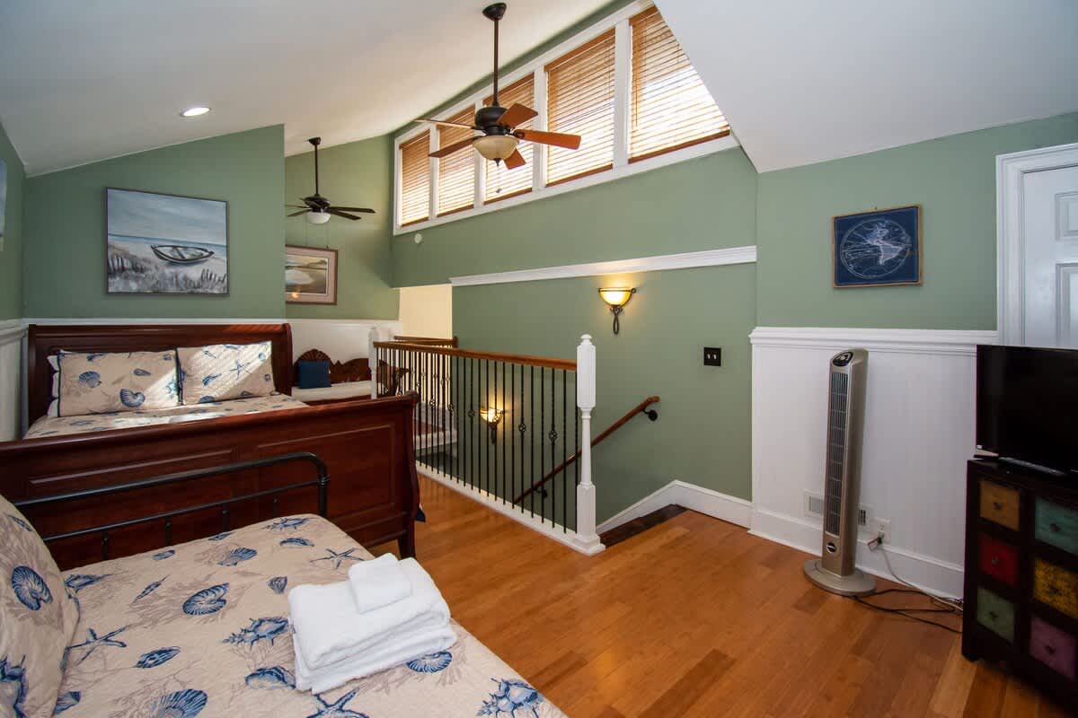 Second floor bedroom area with queen bed, trundle day bed, and en suite full bathroom.