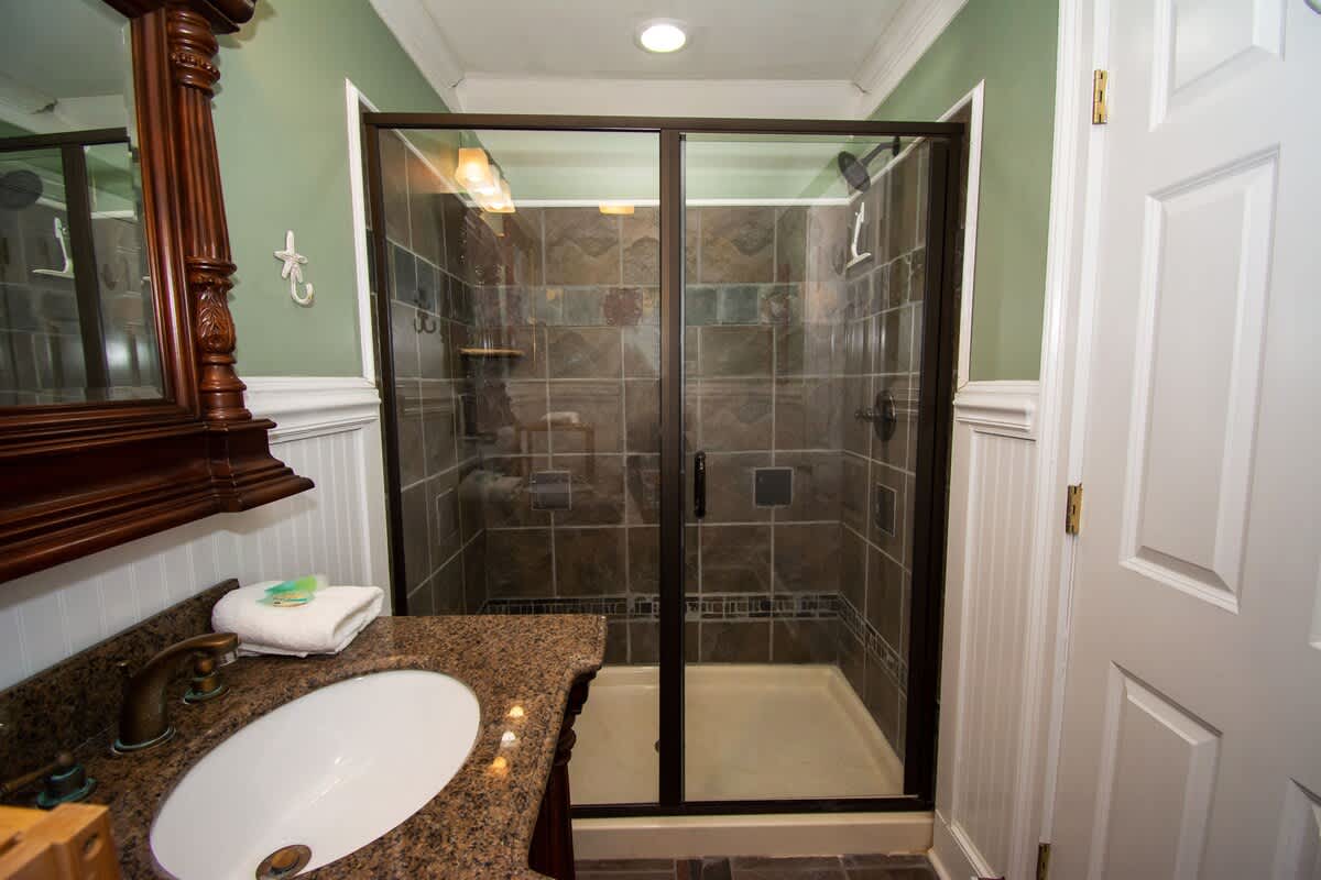 Second floor bedroom area with queen bed, trundle day bed, and en suite full bathroom.