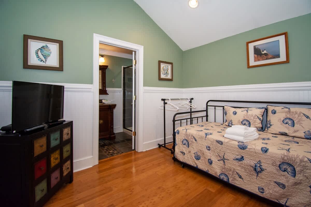 Second floor bedroom area with queen bed, trundle day bed, and en suite full bathroom.