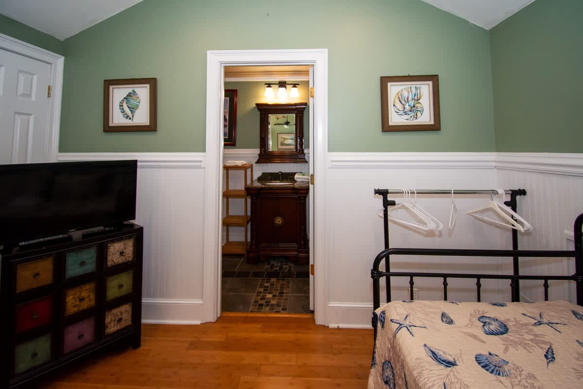 Second floor bedroom area with queen bed, trundle day bed, and en suite full bathroom.