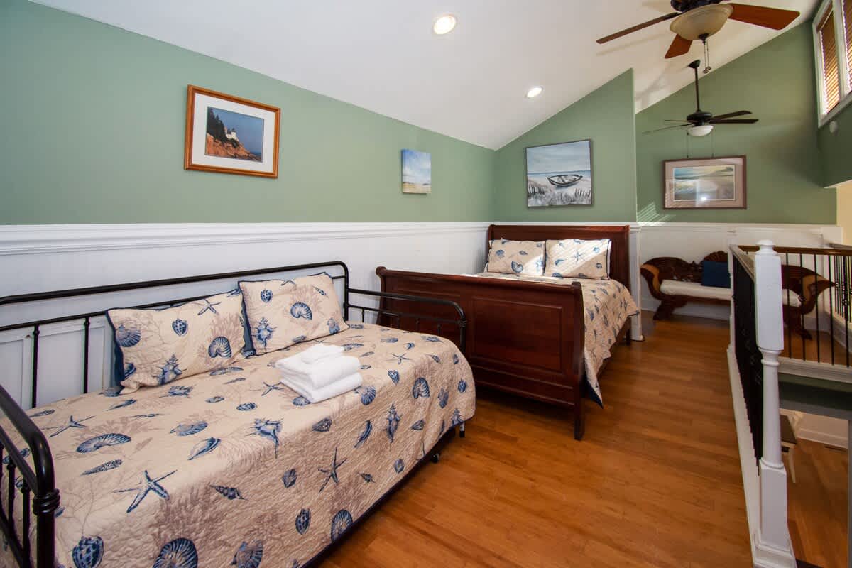 Second floor bedroom area with queen bed, trundle day bed, and en suite full bathroom.